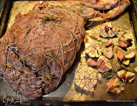 Налейте в противень оливковое масло, уложите баранью ногу, разрезанную пополам большую головку чеснока. Посыпьте сухим розмарином и поставьте в сильно разогретую духовку (до 230°С) на 10 — 15 мин, чтобы мясо равномерно поджарилось со всех сторон. Для этого периодически поворачивайте ногу на противне.