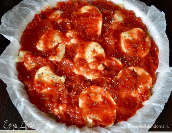 Затем смазать все обильным слоем протертых томатов (пассатой из помидоров) и посыпать орегано. Выпекать в разогретой до 180°С духовке 30 минут.