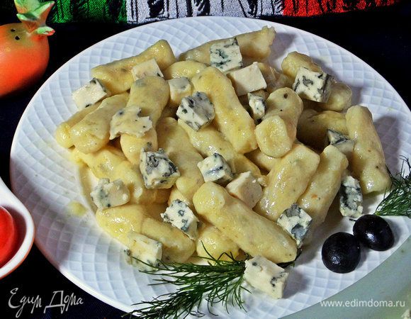 Насыпать горсть сыра сверху на горячие ньокки. Для соуса: нагреть кусочки сыра в сливках или бульоне, довести до кремового состояния и полить сверху.