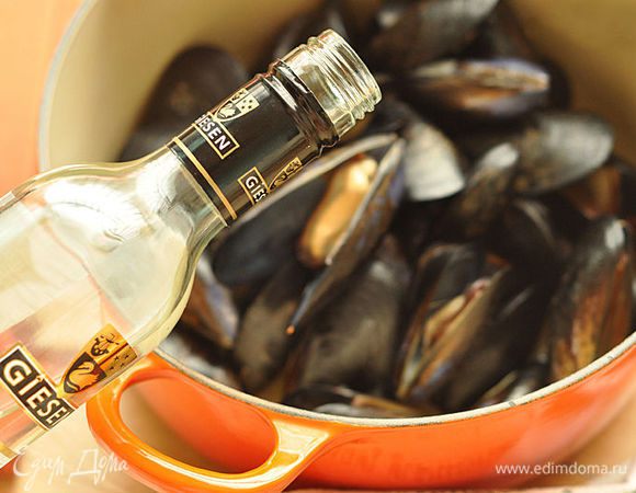 Положить в кастрюлю мидии и обжарить 1 — 2 минуты, пока мидии не раскроются. Полить мидии вином.