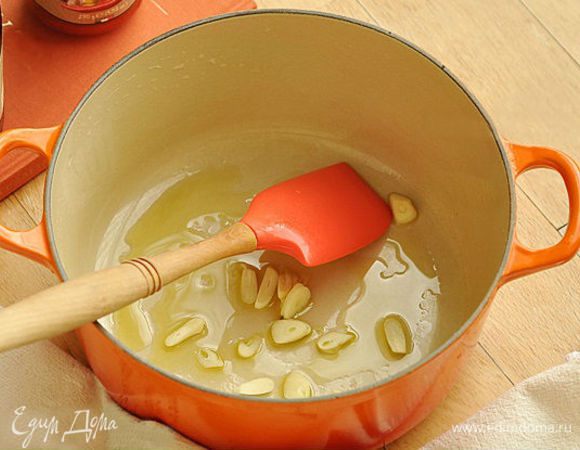 В кастрюлю налить оливковое масло. Нагреть масло и обжарить чеснок в течение 2-х минут на медленном огне.