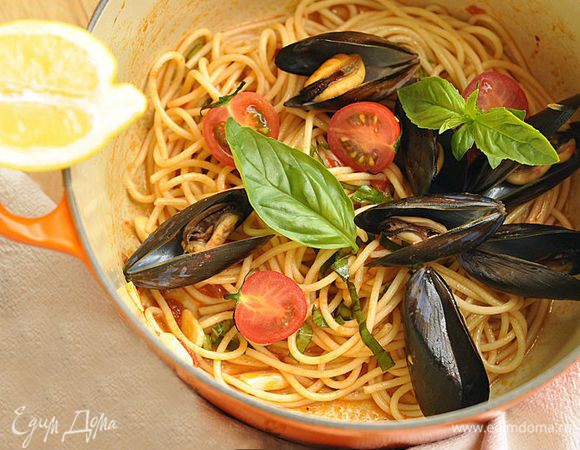 Выложить в кастрюлю мидии и помидоры и потомить 1 минуту. Убрать кастрюлю с плиты и полить блюдо лимонным соком. Можно украсить блюдо листьями базилика.