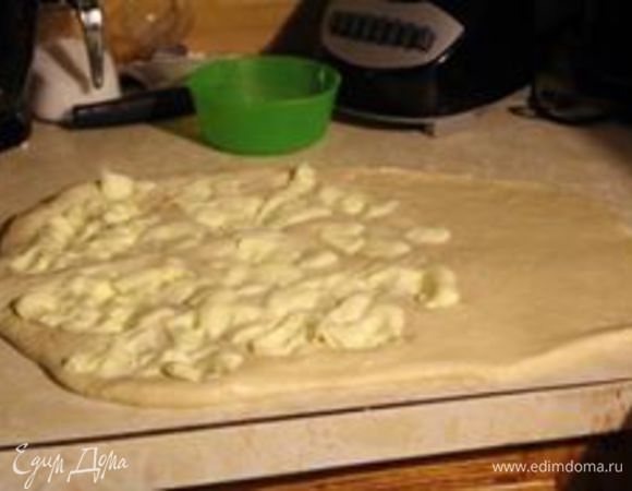 Тесто охладить (минут 10 — 20 в холодильнике). Раскатать в слой в 2 — 3 см и на ⅔ выложить масло. У меня оно кусками легло, как видно на фото. Лучше его между двумя листами пергамента слегка раскатать, а уже потом дотянуть руками на тесте. Посыпать ложкой сахара.