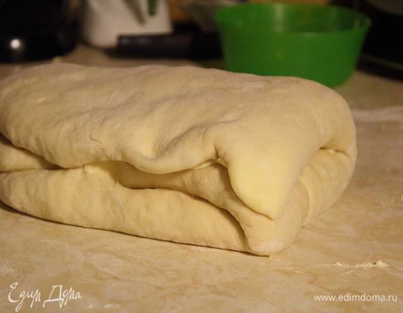 Тесто сложить втрое, не покрытую маслом треть теста завернуть внутрь. Накрыть ее вторым краем теста с маслом.