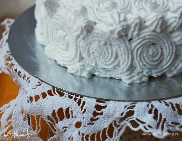 Собираем торт. 
Остывший бисквит разрезаем вдоль на три части (у меня была форма 16 см, у вас может быть больше или меньше и, следовательно, частей может получиться меньше или больше). Каждый корж поливаем сиропом и собираем их в башенку, прослаивая лимонным заварным кремом. Верх также покрываем этим кремом и смазываем торт по бокам. Затем украшаем белковым кремом, закрывая всю поверхность торта, можно просто смазать, а можно сделать узоры или такие розочки, как у меня. Затем ставим торт в холодильник на 1 — 2 часа, чтобы белковый крем чуть схватился, и можно кушать.