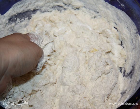 Слегка смешиваем сухие ингредиенты с яйцом и водой, но не вымешиваем тесто основательно. На фото хорошо видно, что тесто еще не вымешено. Вот в этот момент вливаем остывшее растопленное сливочное масло и замешиваем тесто в единый комок. 