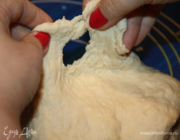 И вот вам тому доказательство. Поднимаем тонкий слой теста вверх и «проверяем его на свет». Оно рыхлое и начинает рваться. Это говорит о том, что ему надо придать эластичность и гладкость. 