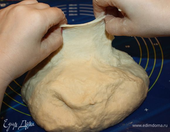 Начинаем вымешивать тесто на рабочей поверхности методом складывания. Нельзя пропускать тесто через пальцы. В среднем на это уходит почти минут 10 — 12. Готовность теста «проверяем на свет»: подняли тонкий пласт вверх и видим, что оно прекрасной гладкой текстуры, просвечивается на свет, а самое главное — оно не рвется. Вот теперь тесто имеет правильную текстуру. 