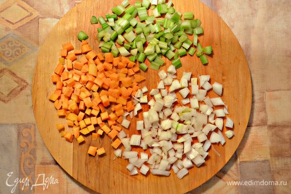 Морковь, лук и сельдерей нарежьте небольшими кубиками. Обжарьте овощную смесь на разогретом оливковом масле 5 мин до размягчения.