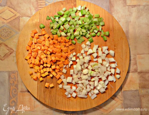 Морковь, лук и сельдерей нарежьте небольшими кубиками. Обжарьте овощную смесь на разогретом оливковом масле 5 мин до размягчения.
