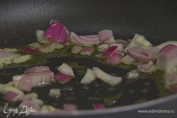 В глубокой тяжелой сковороде разогреть оливковое масло и потушить лук до прозрачности, затем добавить чеснок, измельченный руками чили и обжаривать все пару минут.