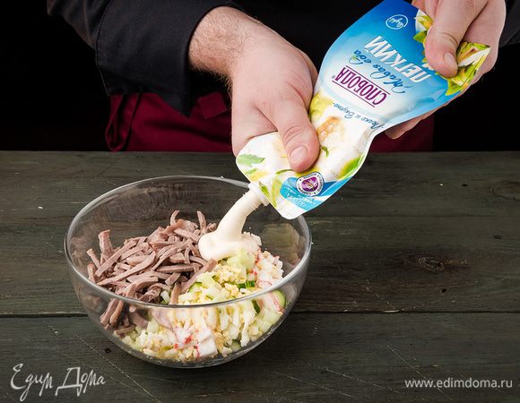 Язык, яйца, крабовые палочки, огурцы соединить и перемешать. Посолить и поперчить. Салат заправить Легким майонезом ТМ «Слобода».