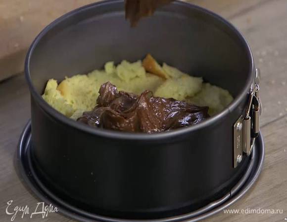 Бриошь нарезать тонкими ломтиками и уложить на дно маленькой разъемной формы для выпечки, так чтобы получился корж, сверху выложить половину сливочно-шоколадной массы.