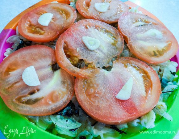 Сверху выкладываем тонко нарезанные дольки помидора, а на них — чеснок. Покрываем будущую запеканку тертым сыром и отправляем в духовку на 10 — 15 минут (при температуре 180°С). 