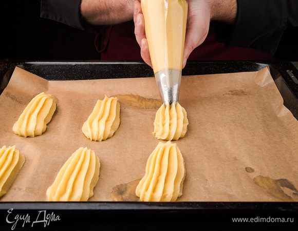 На противень выложить пергамент, переложить тесто в кондитерский мешок, порционно разложить тесто. Выпекать сначала при 220°С 10 минут, потом переставить на 160°С и выпекать 20 минут.