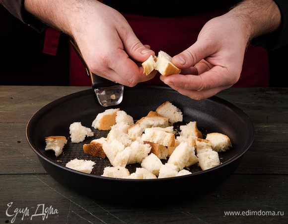 Хлеб нарезать кубиками и подсушить в духовке. С ананаса слить жидкость. Листья салата порвать. Сыр натереть на крупной терке.
