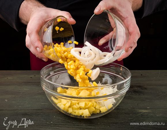 В салатник выложить картофель, сверху — кальмары и лук (предварительно слить воду). Далее выкладываем кукурузу, добавляем специи по вкусу.