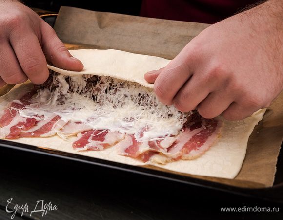 Посыпаем фарш сыром и сворачиваем тесто в рулет.