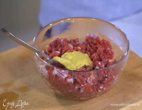 К фаршу добавить измельченный лук и чеснок, 1 ч. ложку горчицы, все посолить, поперчить и перемешать. Дать фаршу немного постоять.