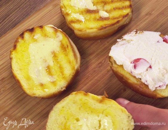 Противень выстелить фольгой, выложить обжаренные ломтики бриоши и смазать их сливочным маслом.