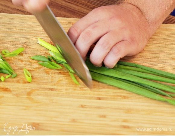 Зеленый лук нарезать наискосок.

