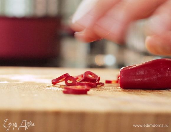 Перец чили мелко порубить, добавить в сковороду, посолить, поперчить и перемешать.
