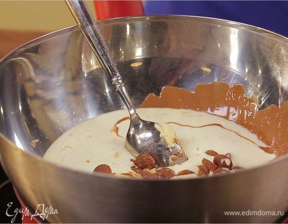 Пока выпекается бисквит можно заняться приготовлением шоколадного ганаша. В сотейнике на водяной бане растопить 50 г масла и 200 г шоколад, влить сливки (33%), размешать и проварить пару минут до загустения. Отставить в сторону и дать крему немного остыть.
