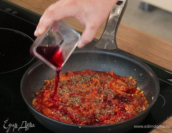 Сразу же добавить ложечку сахара, специи по вкусу (сушеные орегано, базилик) соль и перец. По желанию можно влить 50 мл вина. Перемешать, накрыть сковороду крышкой и потушить соус на медленном огне 20–25 минут.
