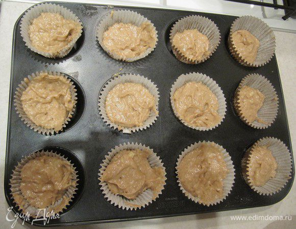 Выложить тесто в формочки для маффинов, заполняя их наполовину.