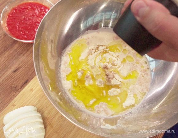 После того как дрожжи растворятся, влить в пшеничную муку, добавить оливковое масло, соль. 
