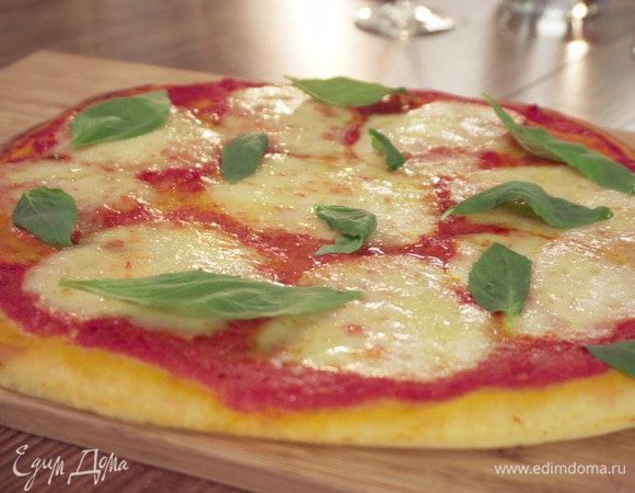 Выпекать в разогретой духовке 6–8 минут. Готовую пиццу украсить базиликом.