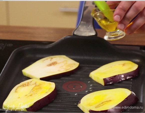 Баклажаны нарезать тонкими пластинами. По желанию замочить в воде с солью (на 1 час), после чего промыть и обсушить. Обжарить баклажаны с двух сторон в арахисовом масле до приобретения золотистого цвета. Выложить на бумажное полотенце, чтобы убрать лишний жир.