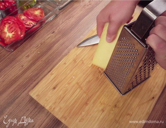 Снимите сливочный соус с огня и отставьте в сторону. Спелые помидоры нарежьте кружочками. Сыр натрите на терке.
