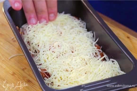 Таким образом продолжайте выкладывать слои, пока не закончатся ингредиенты. Сверху полейте лазанью оставшимся сливочным соусом, выложите ломтики помидоров, присыпьте сыром. Запекайте при 180°С 35 минут до золотистого цвета.