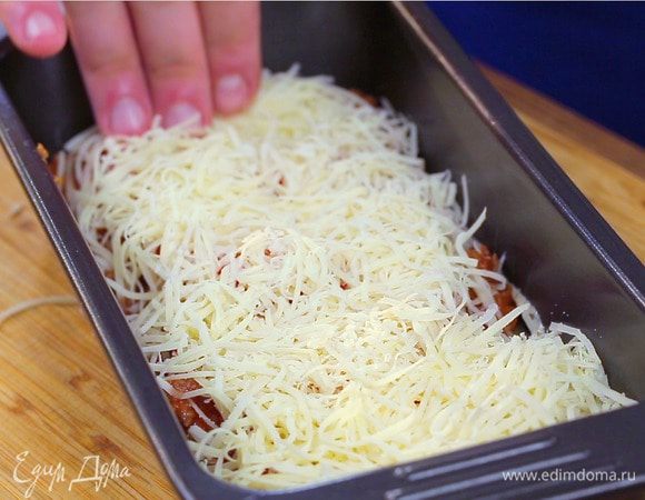 Таким образом продолжайте выкладывать слои, пока не закончатся ингредиенты. Сверху полейте лазанью оставшимся сливочным соусом, выложите ломтики помидоров, присыпьте сыром. Запекайте при 180°С 35 минут до золотистого цвета.
