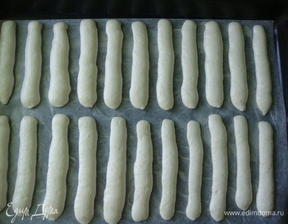 Противень застелить пекарской бумагой и смазать сливочным маслом. Тесто выложить в кондитерский мешок без насадки и отсадить полоски длиной 10 см. Делайте промежутки между печеньем побольше, а то у меня они в процессе выпекания немного слиплись.