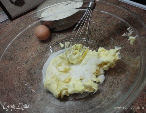 Тесто готовим теплым способом. Поэтому масло надо заранее достать из холодильника и дать ему размягчиться. 
Включаем духовку для разогрева до 210°С и приступаем к замесу теста. Мягкое масло взбиваем с 1 столовой ложкой сахара, добавляем яйцо, еще немного взбиваем, затем добавляем сметану и перемешиваем. 