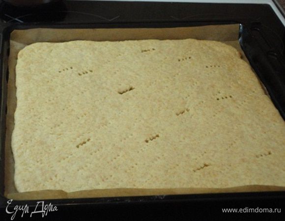 Мне хватило 15 минут при температуре 210°С. На фото может показаться слишком бледной выпечка, но в действительности она румяная. Готовый лист в теплом виде подравниваем с краев и разрезаем на две равные половины. Я из практики пришла к выводу, что разрезать и равнять песочное тесто лучше горячим, оно не так ломается.