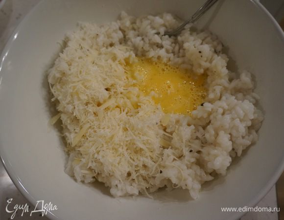Рис снимаем с огня. Солим по вкусу, добавляем сливочное масло, тертый пармезан и яйцо. Перемешиваем. 