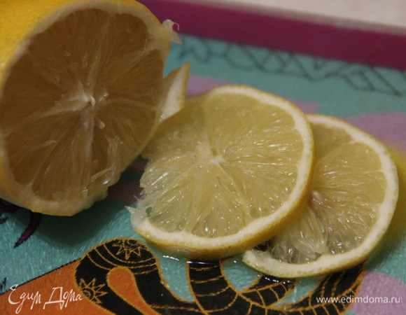 Тем временем нарежем пару долек лимона и тоже добавим в напиток. Оставим настой на 15 минут.