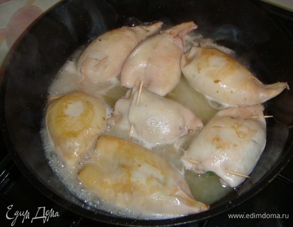 Сковороду разогреть, налить оливковое масло и выложить кальмары. Немного их обжарить с двух сторон. Налить оставшееся вино и положить перец чили. Посолить по вкусу и тушить на слабом огне минут 30, периодически переворачивая кальмары.