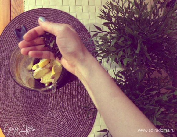 Возьмите заварочный чайник, добавьте в него нарезанный лимон, имбирь и черный чай.