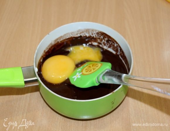 По одному ввести яйца в шоколадную смесь, тщательно перемешать.