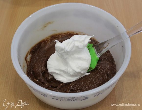 Осторожно частями ввести белки, перемешивая лопаточкой снизу-вверх.