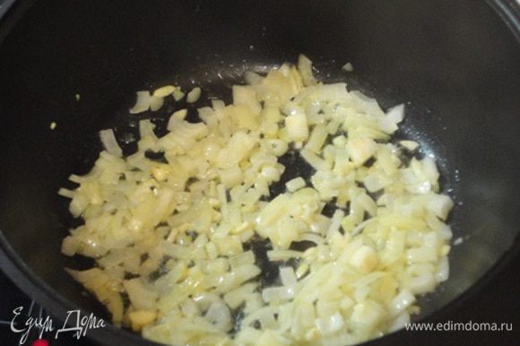 В чугунной сковороде или казане разогрейте растительное и сливочное масло, и прожарьте до мягкости мелко нарезанный лук и чеснок.