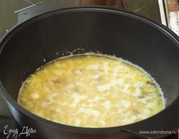 Влейте бульон, посолите. Добавьте перловую крупу и промытый изюм и  дайте закипеть, убавьте огонь и варите до готовности, пока не испарится жидкость, минут 40.