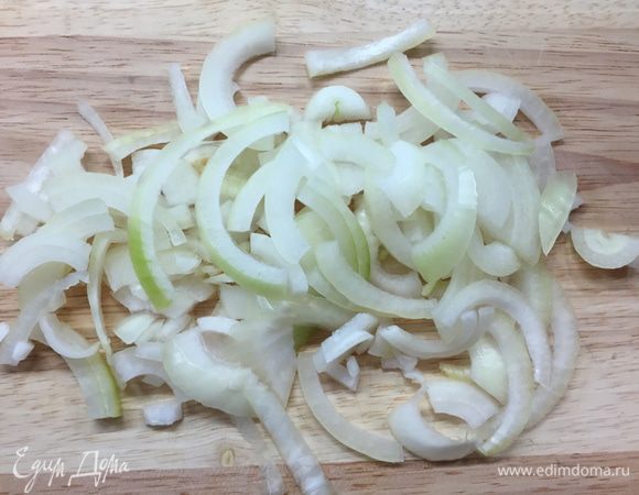 Сразу ставим большую кастрюлю с подсоленной водой на огонь, пусть закипает потихоньку. Разогреваем духовку до 120°С и ставим в нее пустую форму, в которой будем подавать готовый казешпецле. Секрет в том, чтобы она была горячая, когда наступит момент сборки блюда. А пока подготовим лук. Режем нетолстыми кольцами и делим их на четвертинки, затем слегка разминаем в руках, чтобы разделить на полоски.