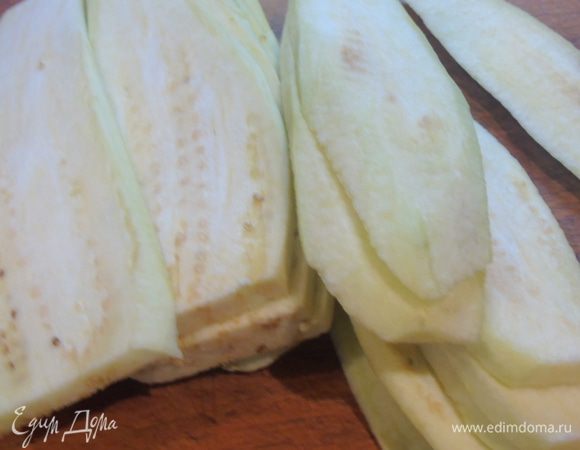 Баклажаны моем, очищаем от кожуры и нарезаем пластинами.