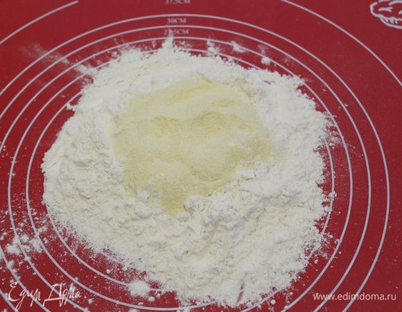 Отвесьте нужное количество муки и семолины, насыпьте горкой, перемешайте.