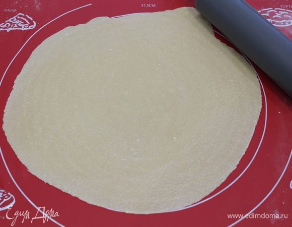 Разделите тесто на две части, одну держите в пакете. Вторую раскатайте, слегка припылив поверхность стола (коврика) мукой. Раскатать нужно довольно тонко и равномерно (у меня были видны полоски коврика).